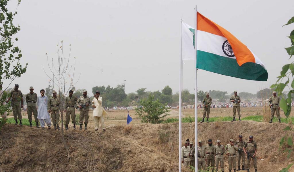 Pakistan ranger stands near the flags of India and Pakistan at zero line international border